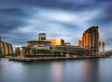 A panoramic photograph of Media City At Salford Quays, Greater Manchester, UK. Featuring a stormy moody sky.